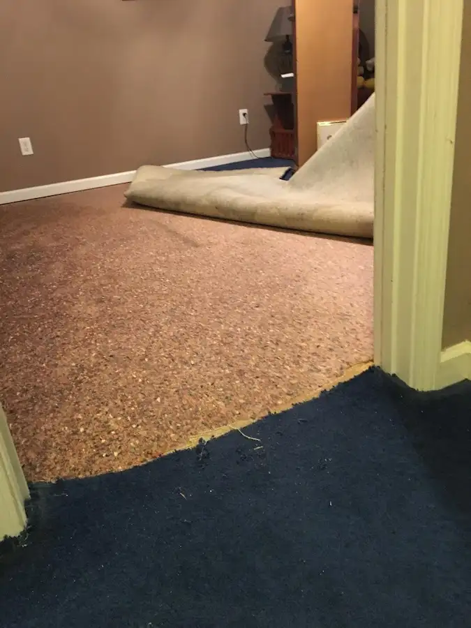 Carpet pad removal revealing water damage during Water Mitigation Services in Tulsa